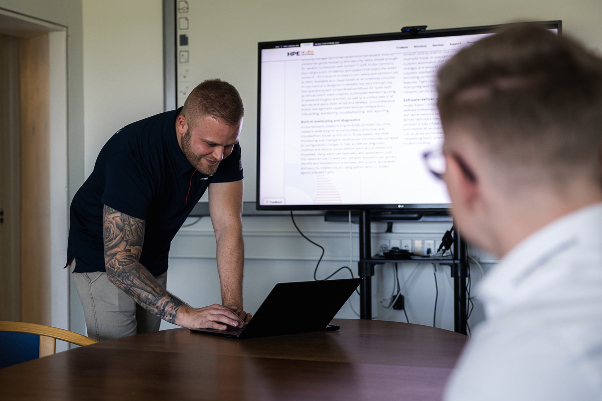 Engageret kollega fremlægger en dynamisk præsentation via storskærm og computer. Denne professionelle scene indfanger Alexander Fabechs ekspertise og dedikation inden for infrastruktur og IT. Oplev vores teamleder i aktion, som deler indsigt og viden, mens vi stræber efter excellence i IT-verdenen. Opdag Kortermann-ITs innovative tilgang og engagerende præsentationer for at forbedre IT-løsninger inden for infrastruktur, servere, netværk og cloudløsninger.